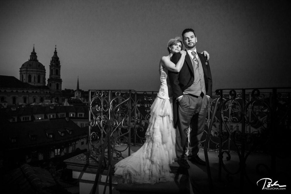 bride and groom standing on a terrace with a view over city in the background